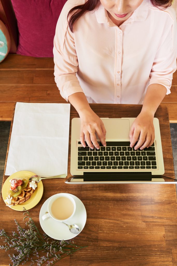 Laptop Arbeit im Cafe mit Kaffee und Törtchen