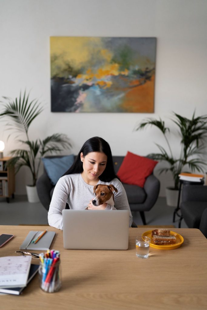 Frau im Home Office mit Hund auf dem Schoß