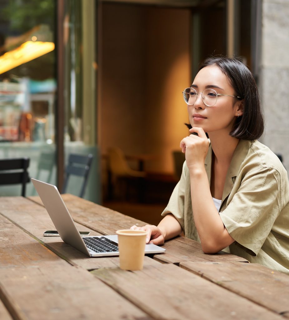 Frau mit Laptop und Kaffee in einem Cafe